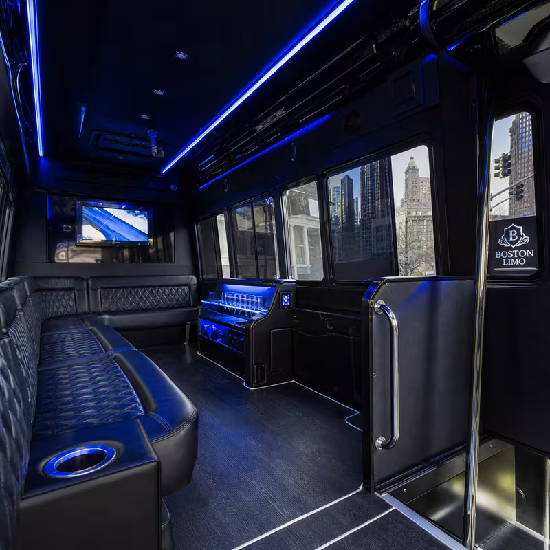 Party bus interior with wraparound leather seating and LED lighting in Boston