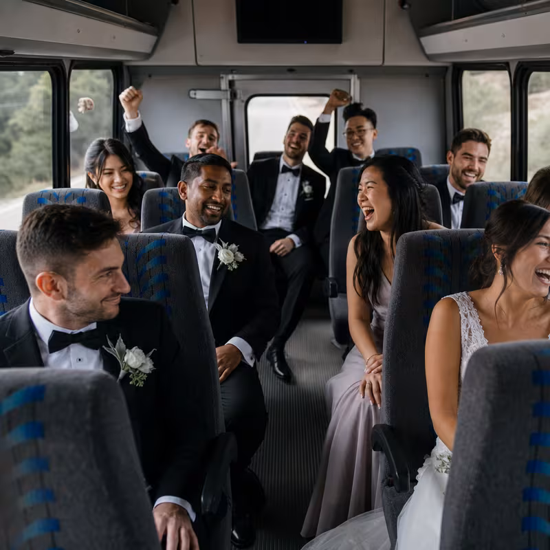 Group boarding a white charter bus for Wedding Transportation transportation in Boston